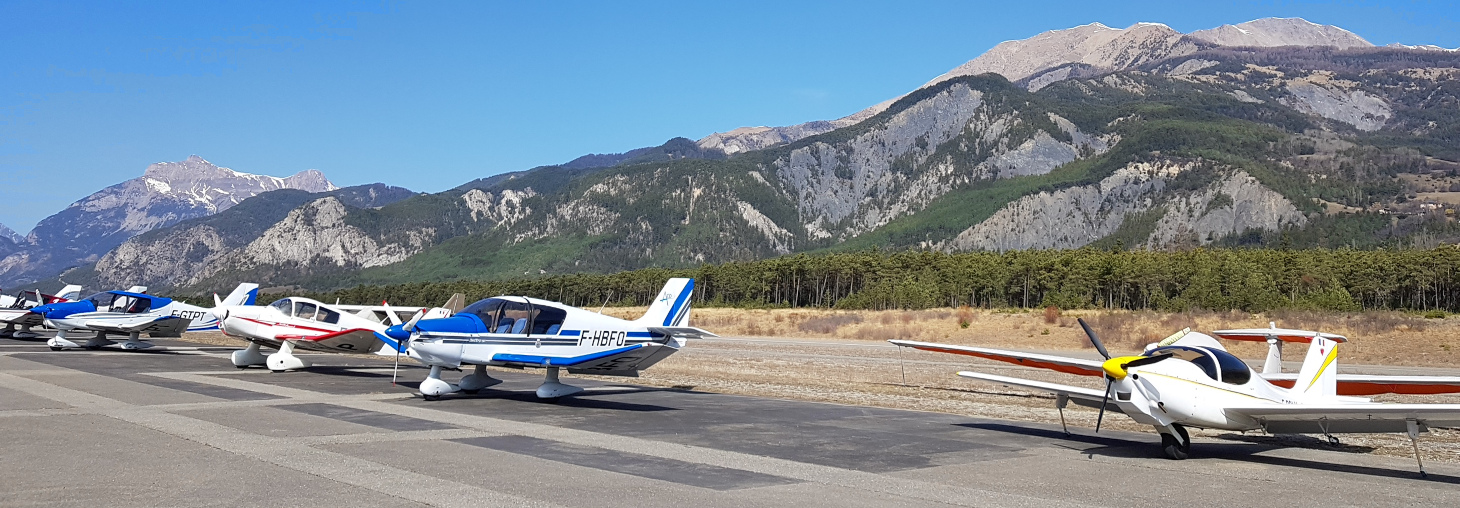 Avions au parking au cours d'une sortie du CSE Aéroclub sur fond de montagnes